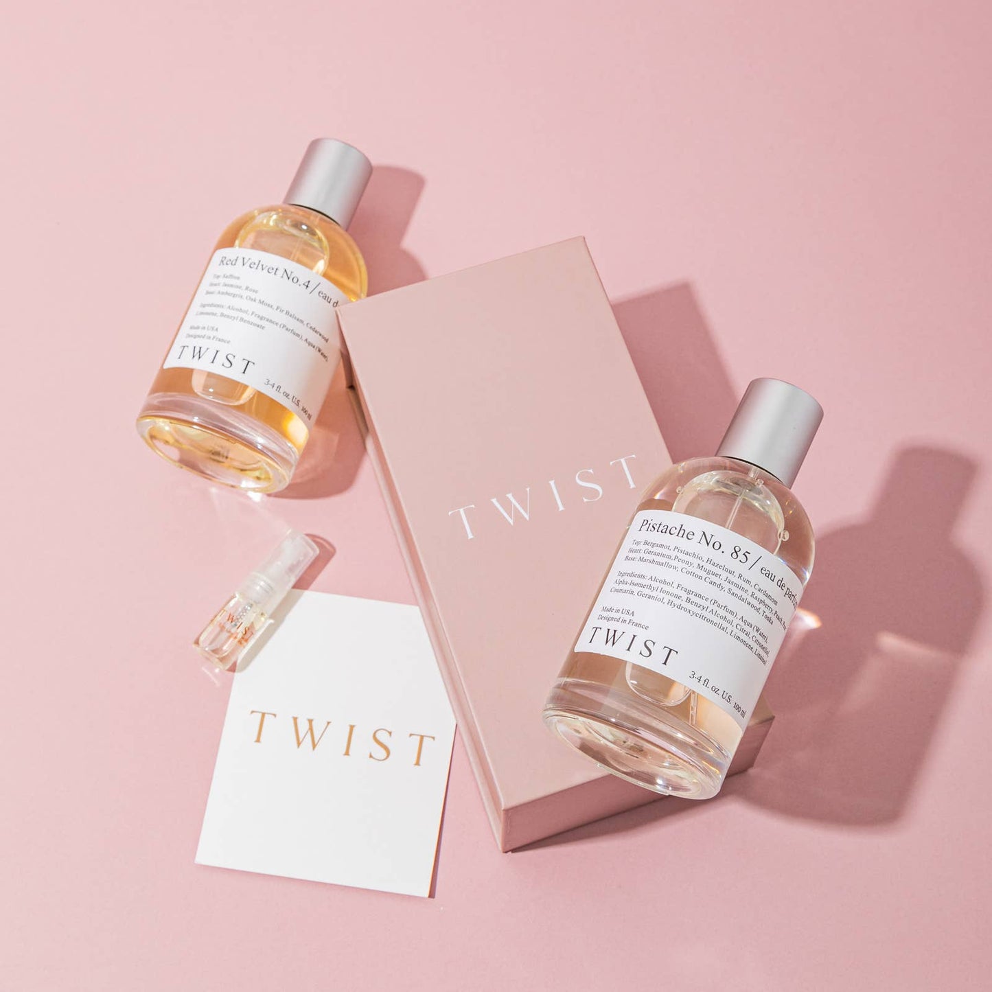 Two bottles of 'TWIST' on a pink background