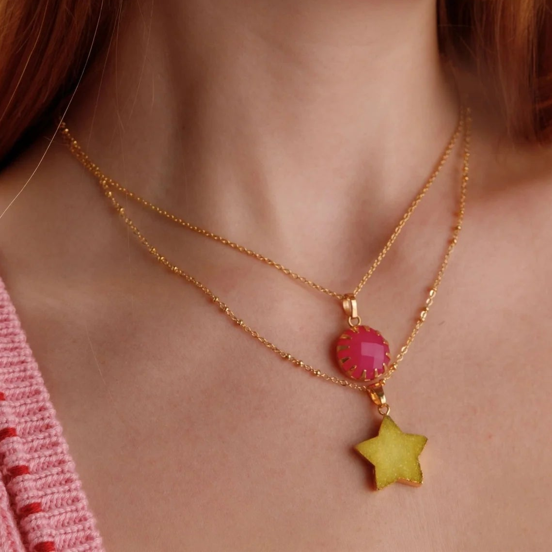 Close-up of a woman wearing gold hoop earrings and necklaces with colorful beads.