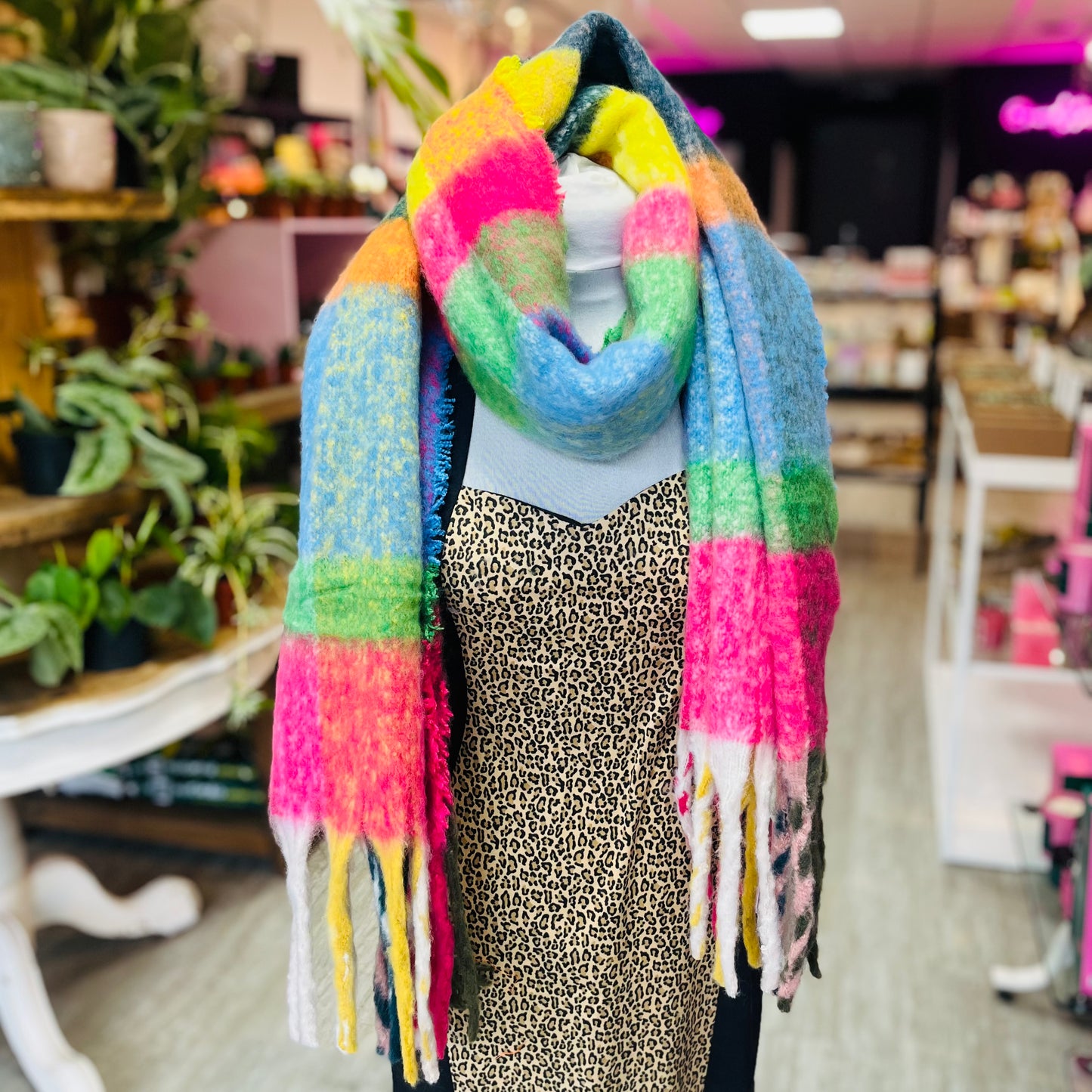 Mannequin wearing a colorful scarf in a store setting