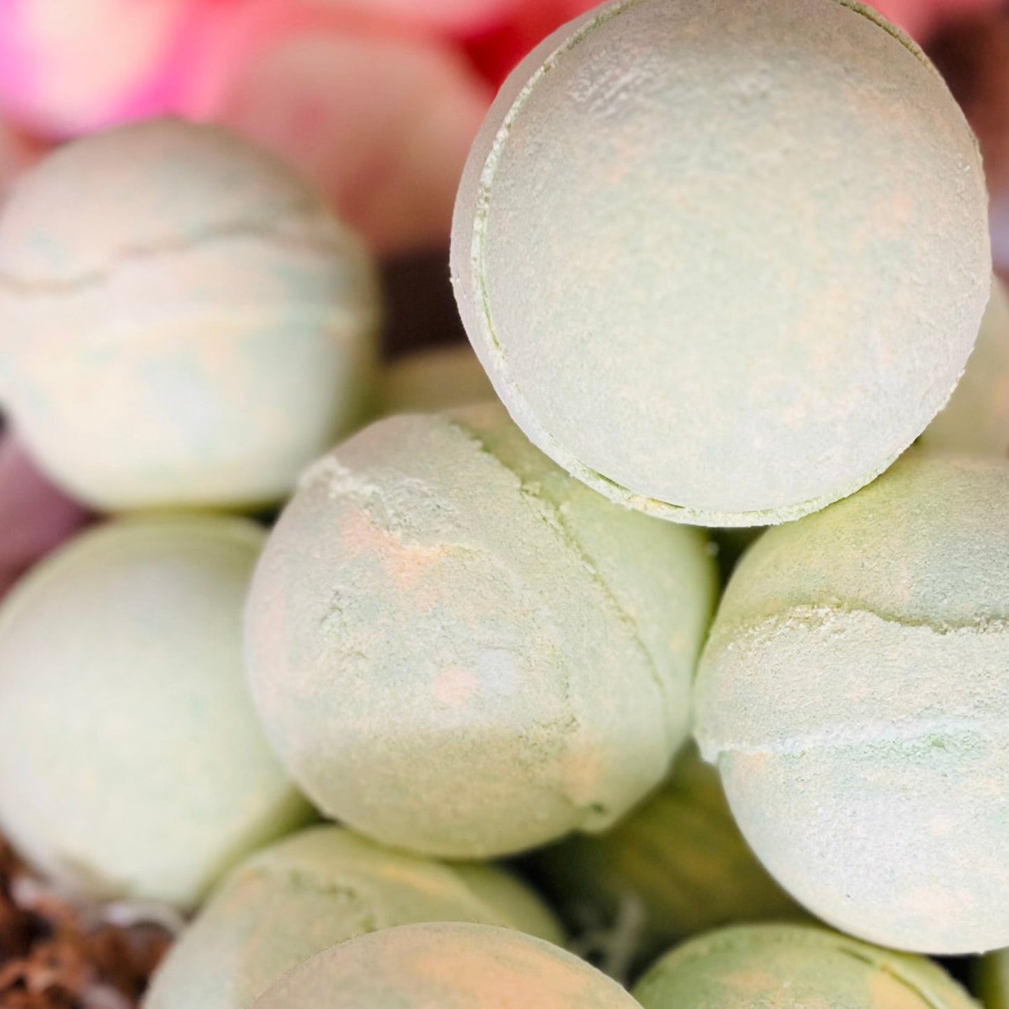 A selection of melon bath bombs, each a shade of pale green.