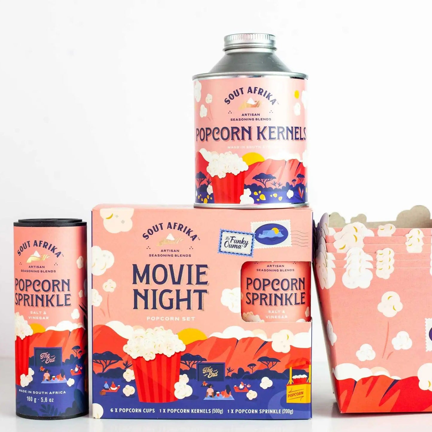 Collection of South Africa popcorn-themed packaging including cans and boxes on a white background