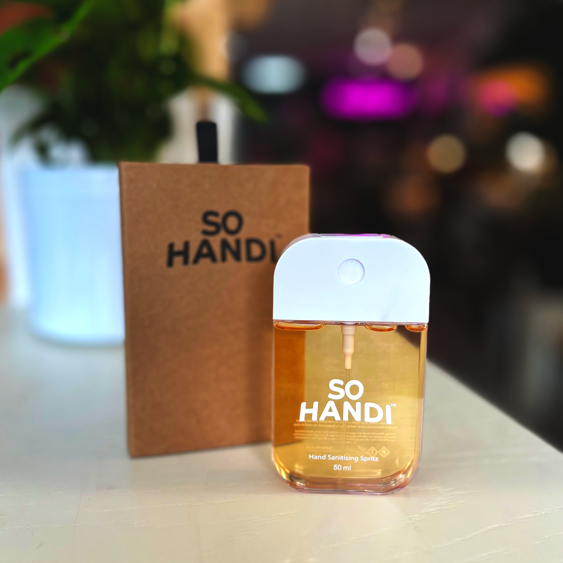 A rectangular spritzer bottle of an orange-coloured hand sanitiser made by So Handi.