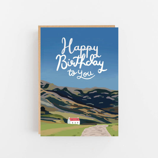 Greeting card with a scenic illustration of mountains and a house, and 'Happy Birthday to You' text.