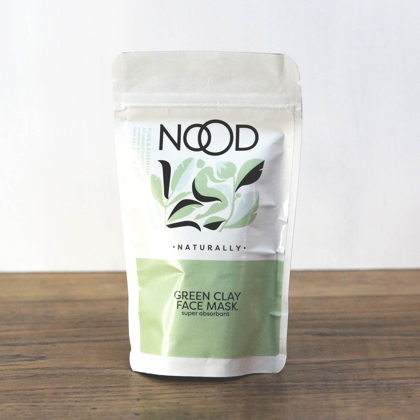 A packaged NOOD Stores Green Clay Face Mask on a white surface, with the product name and description visible.