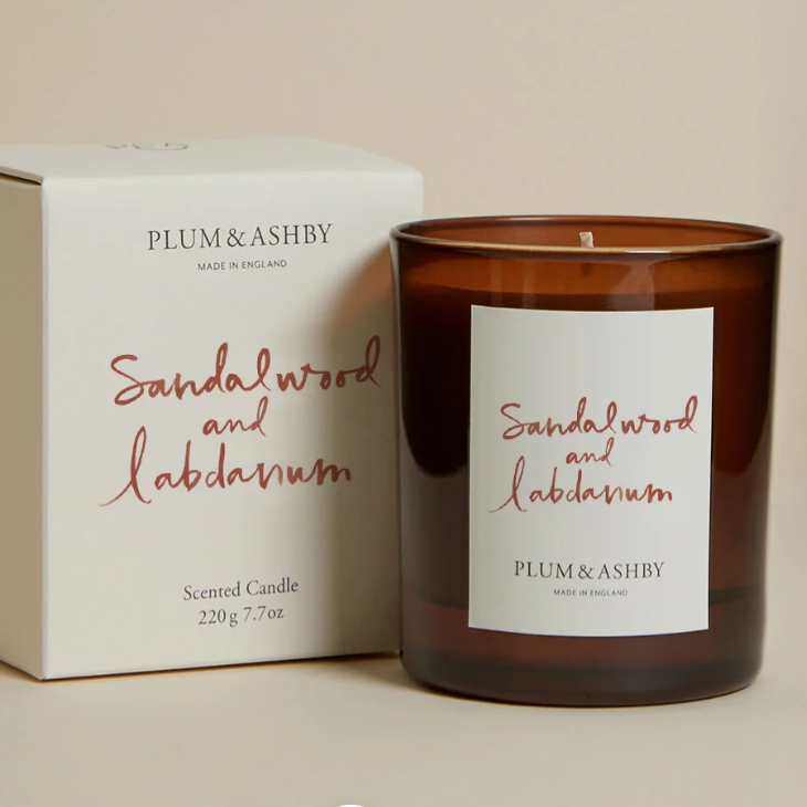 Plum & Ashby sandalwood and labdanum candle with packaging on a beige background