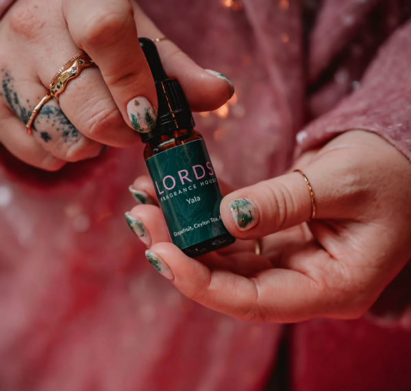 Hand holding a bottle labeled 'LORDS' against a blurred background