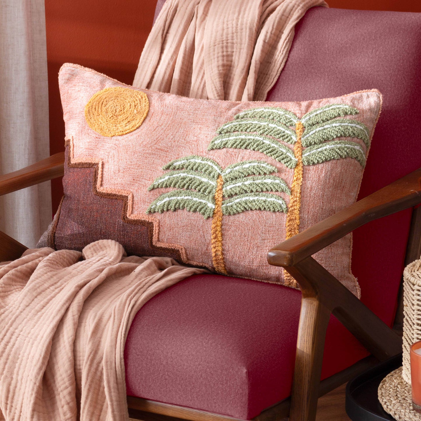 Decorative pillow with palm tree design on a pink chair