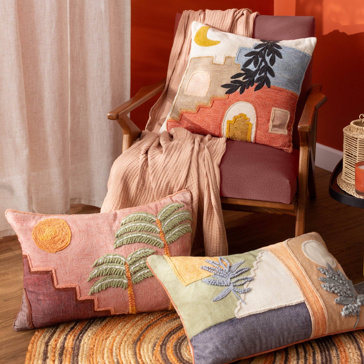 Decorative pillows with embroidered designs on a chair against a warm-toned wall.
