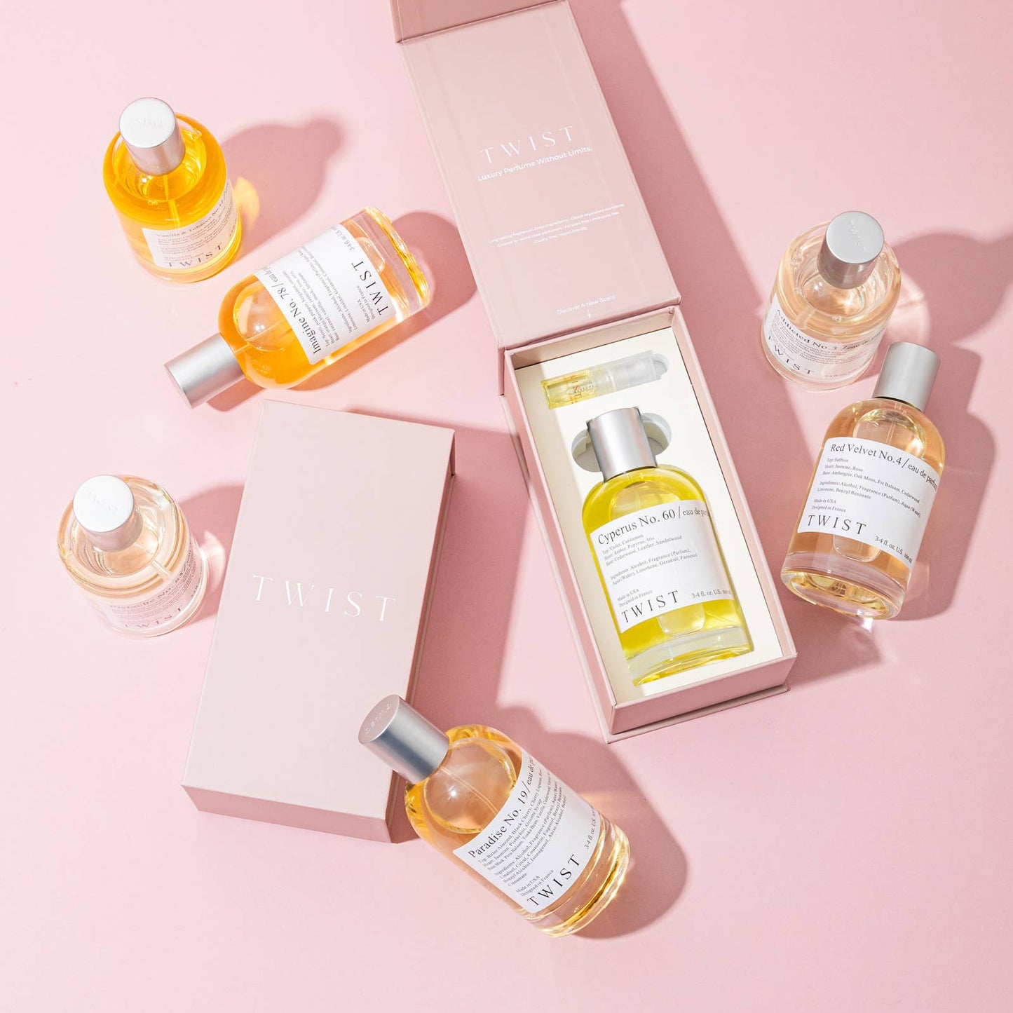 Set of skincare bottles with a pink box on a pink background