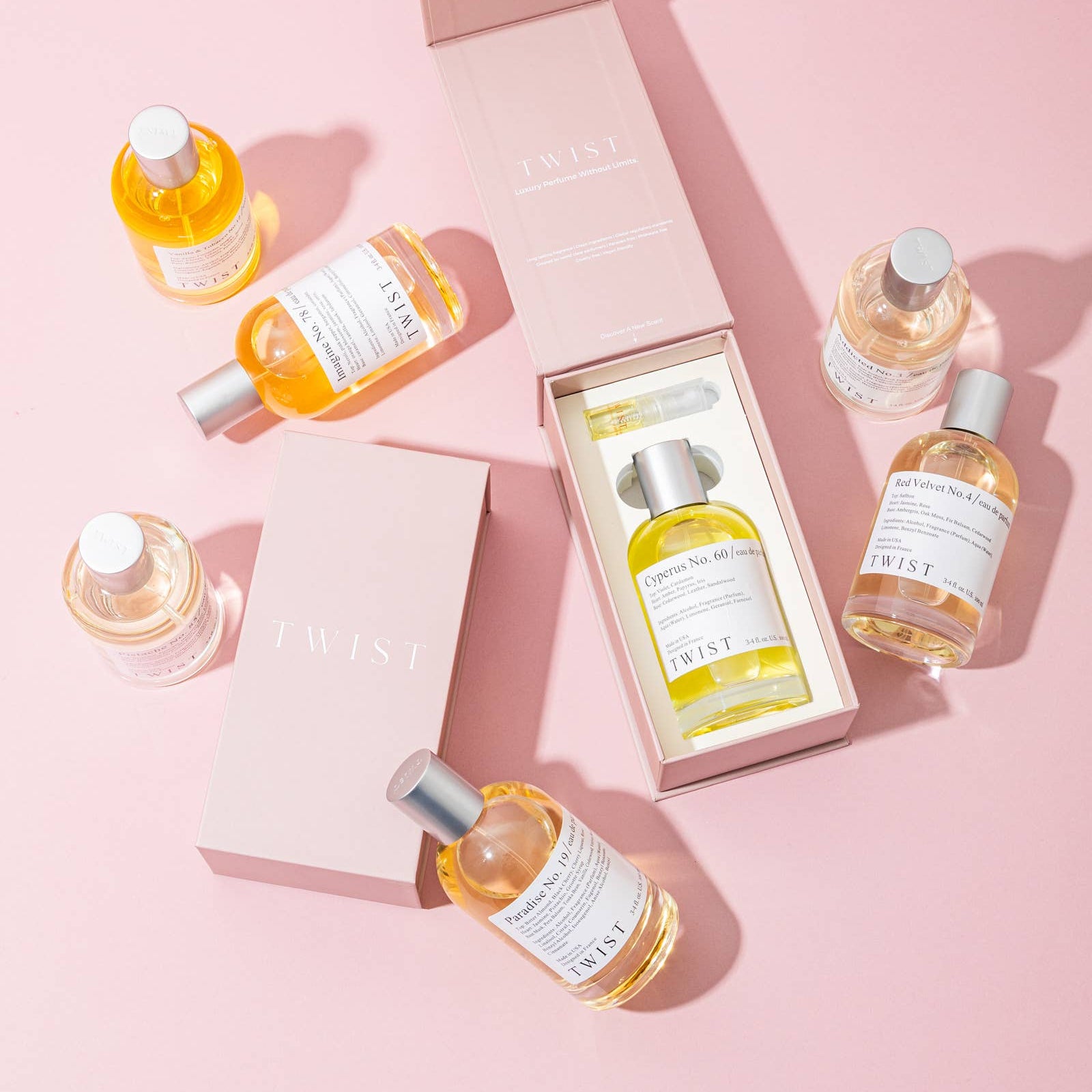 Set of skincare bottles with a pink box on a pink background