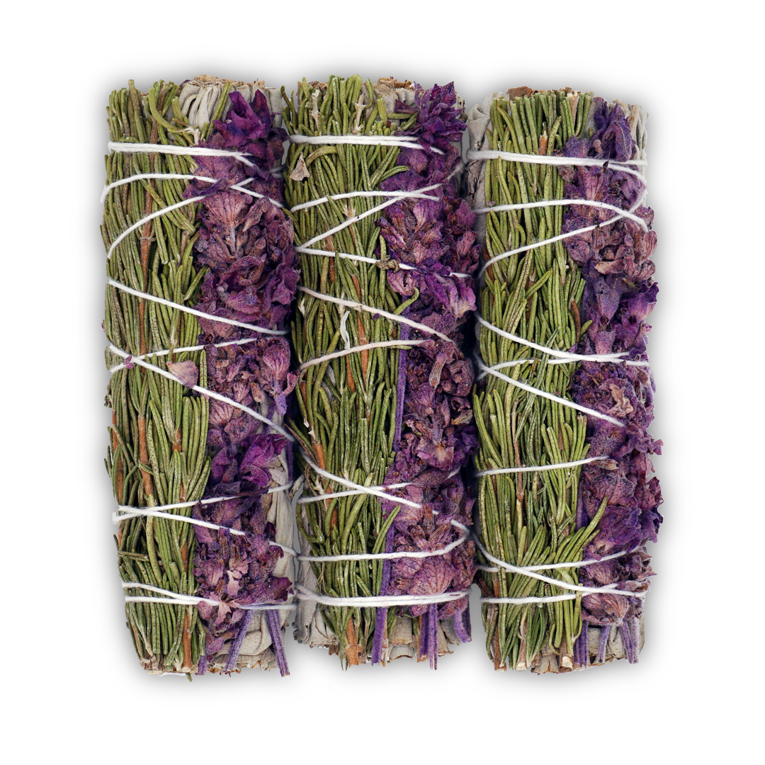 Three bundles of lavender and green herbs tied together with twine on a white background