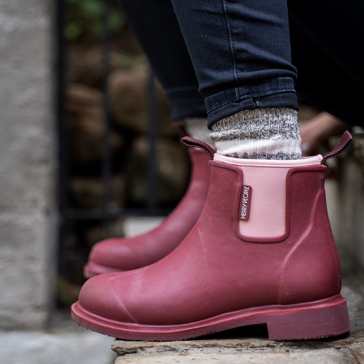 Person wearing pink rubber boots with a blurred background