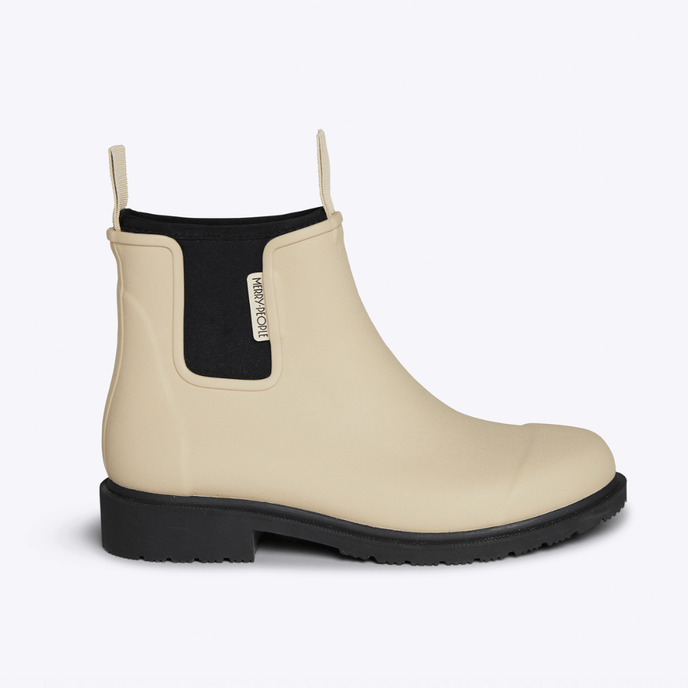 Beige rain boot with black sole on a white background