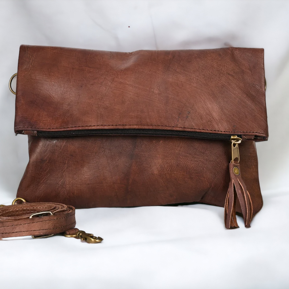 Brown leather clutch bag with a strap on a white background