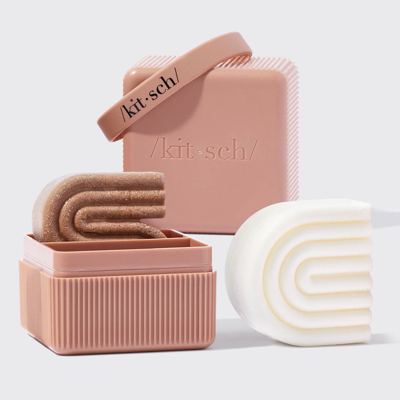 Kit Sch soap products including a bar, a container with soap, and a wrapped bar on a light background.