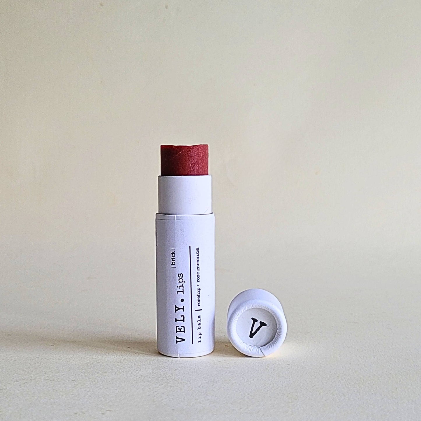 White lip balm with red cap on a beige background