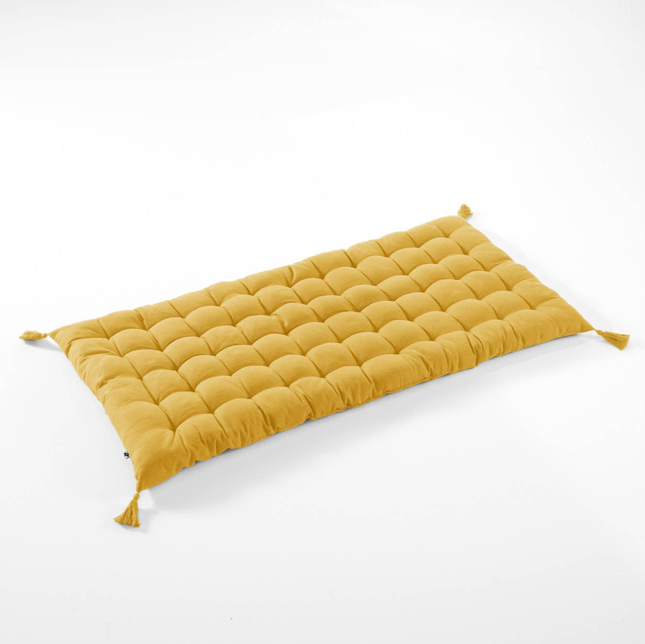 Yellow quilted cushion on a white background