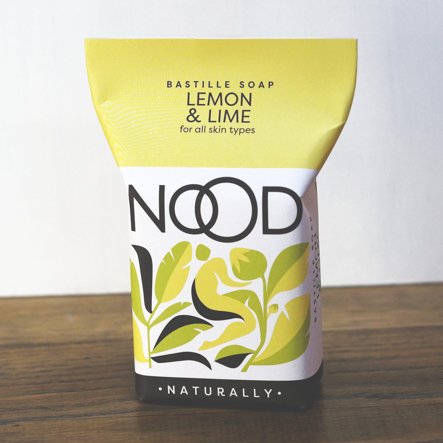 A packaged bar of bastille soap with white, yellow and black packaging. Branded with 'NOOD'. Packaging indicates that this soap is 'for all skin types.'