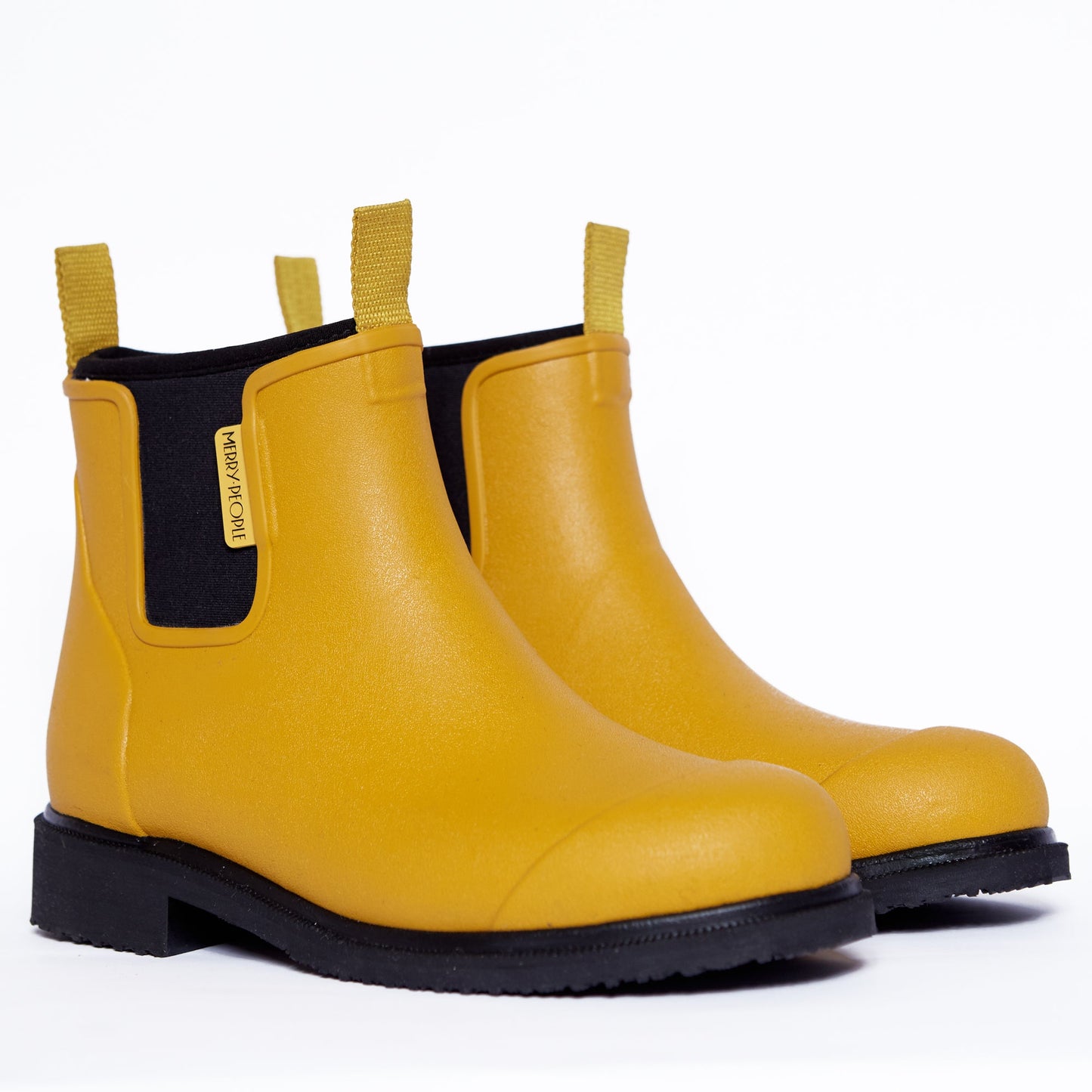 Pair of yellow rain boots with black soles on a white background