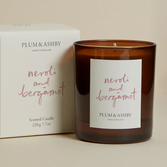 Plum & Ashley scented candle with packaging on a beige background