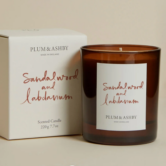 Plum & Ashby sandalwood and labdanum candle with packaging on a beige background