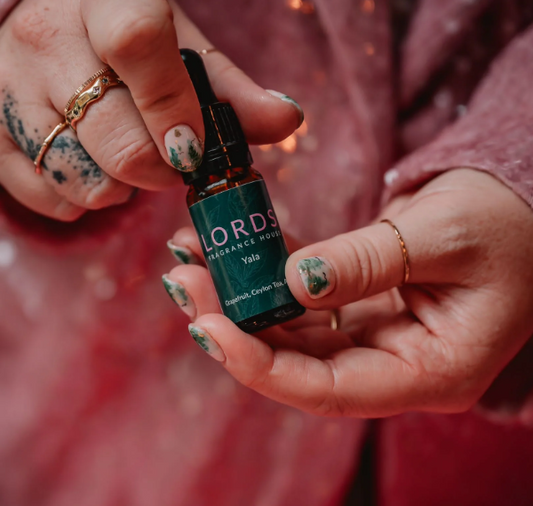 Hand holding a bottle labeled 'LORDS' against a blurred background